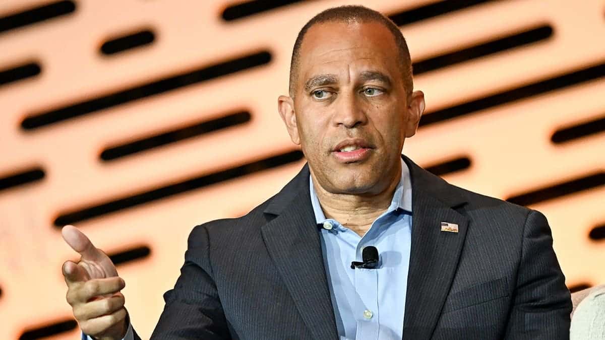 Hakeem Jeffries speaks onstage during a panel discussion at a convention.