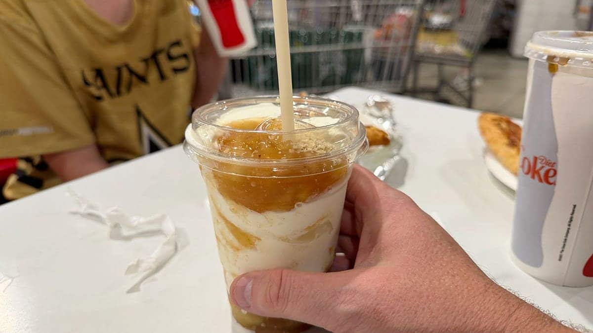 A hand holds an ice cream sundae
