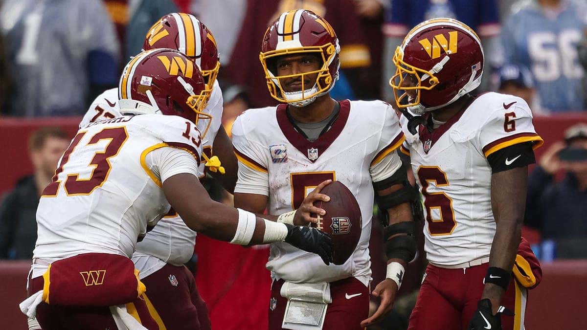Jayden Daniels celebrates with Washington Commanders teammates after scoring a rushing touchdown.