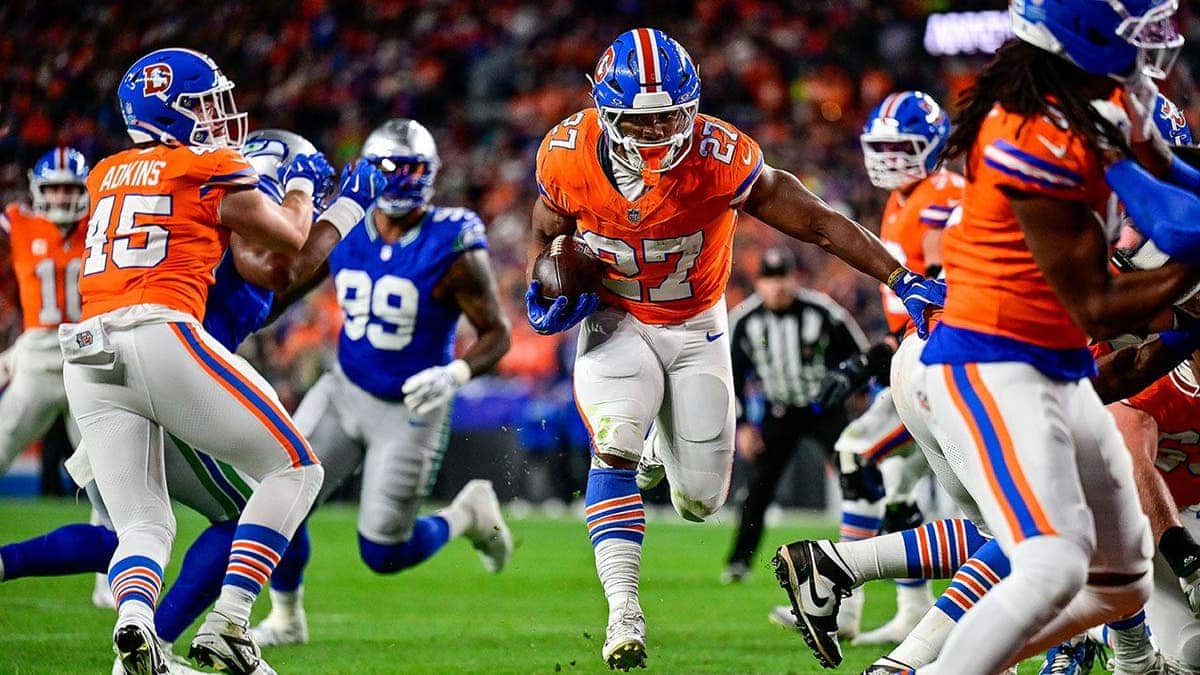 J.K. Dobbins scores a touchdown during a game at Empower Field at Mile High.