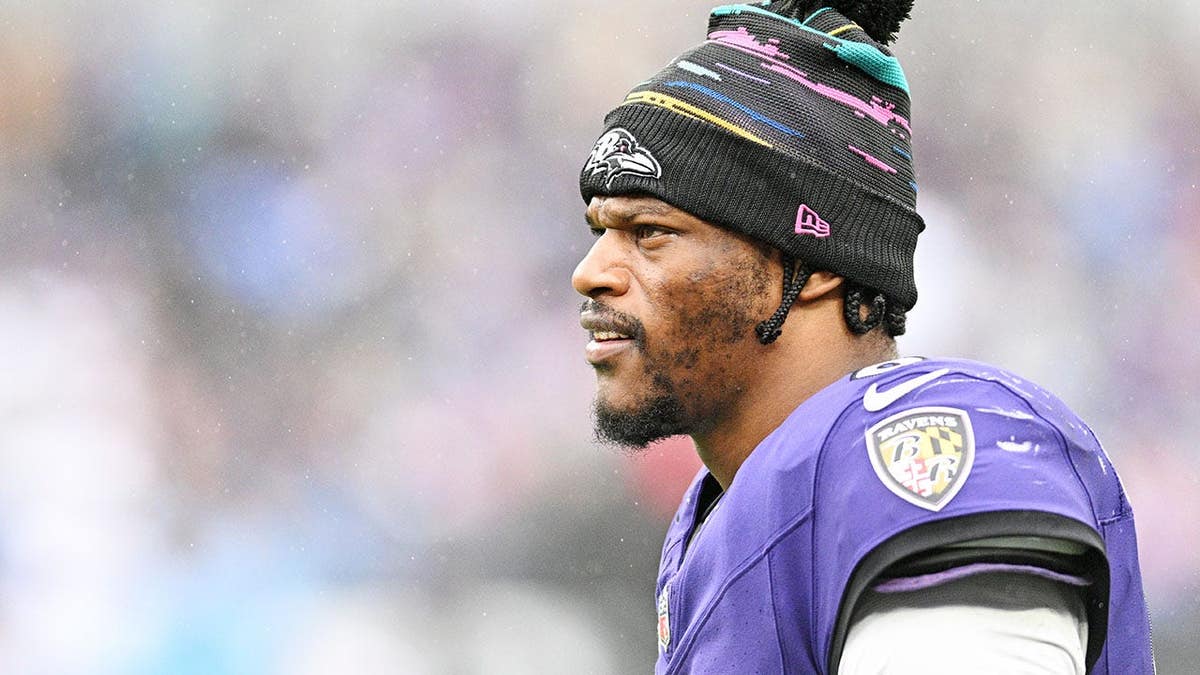 Lamar Jackson sits on the bench after being removed from the game due to a possible injury.
