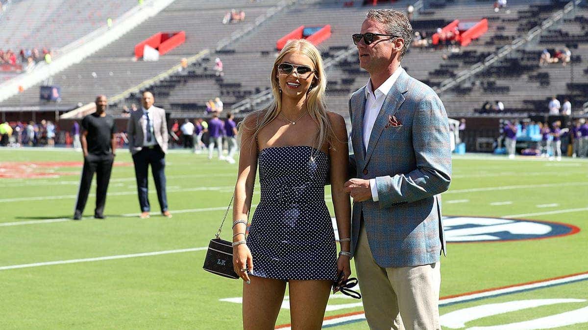 Lane Kiffin poses with his daughter Landry Kiffin before a football game.