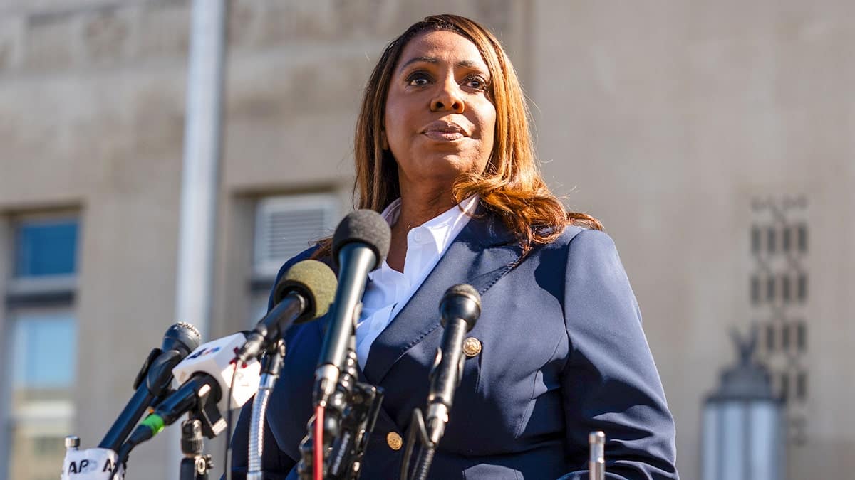 Letitia James stands in front of several microphones