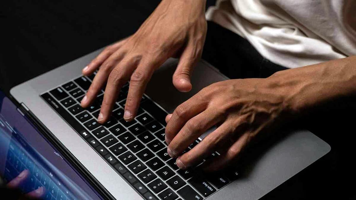 A man typing on a laptop.