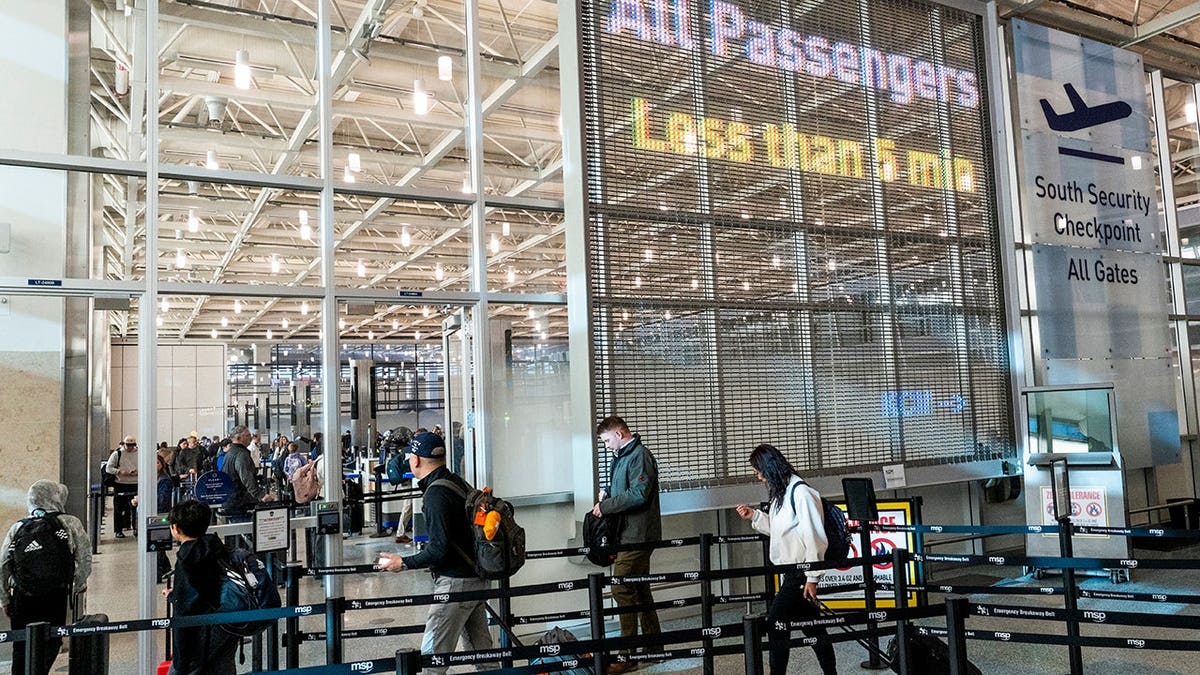 Travelers navigate security lines at Minneapolis-St. Paul International Airport Terminal 1 during a government shutdown.