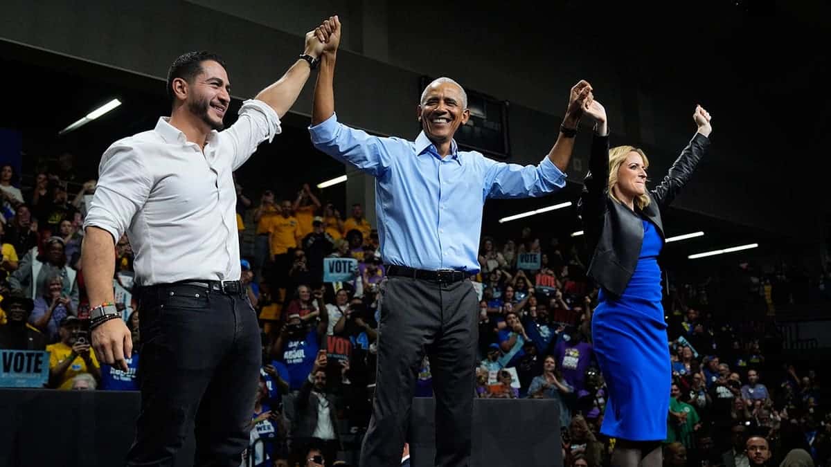 Barack Obama, Abdul El-Sayed and Jocelyn Benson raise their hands at a campaign event.
