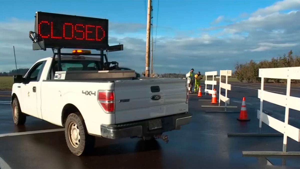 A truck displays a CLOSED sign near McMinnville Airport after an Oregon helicopter collision