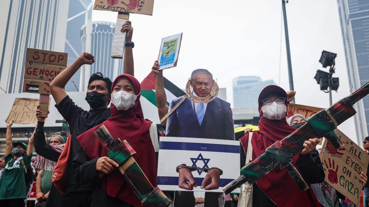 Anti-Israel demonstrators carry a cutout of Benjamin Netanyahu and placards during a rally in Kuala Lumpur.