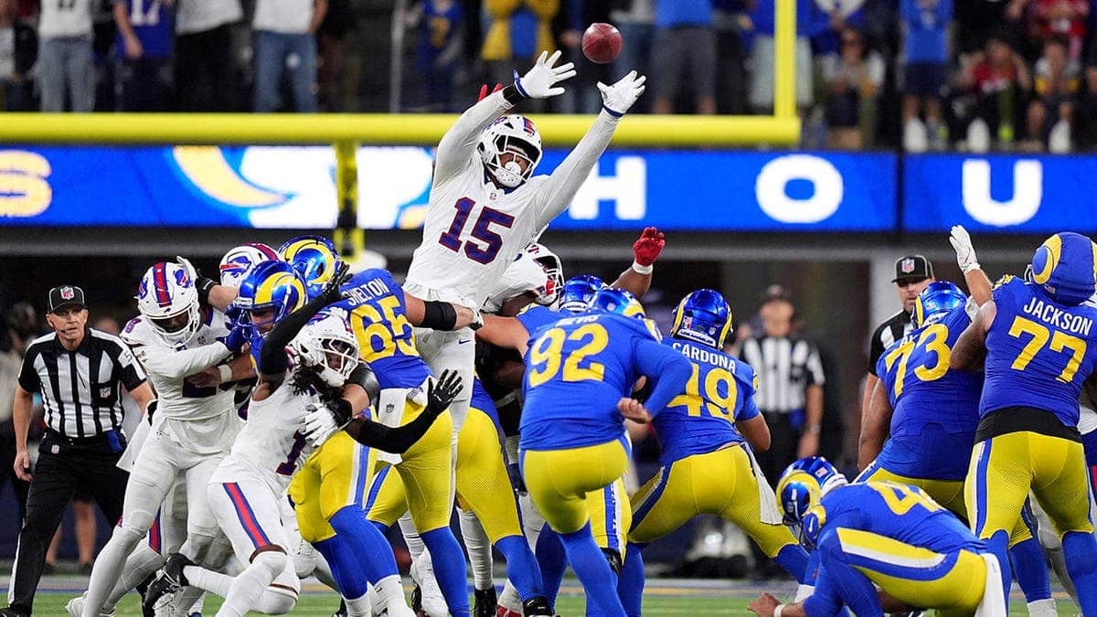 Harrison Mevis attempts a field goal as Greg Rousseau defends during an NFL game.