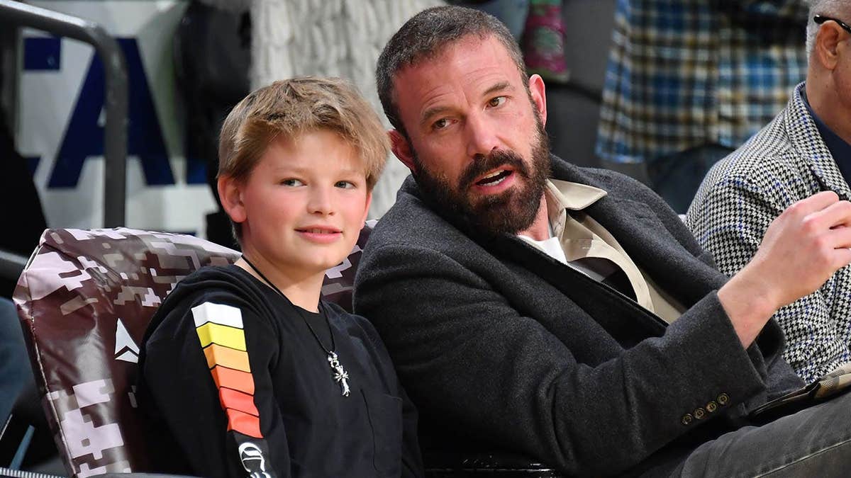 Ben Affleck and Samuel Garner Affleck seated at a basketball game.