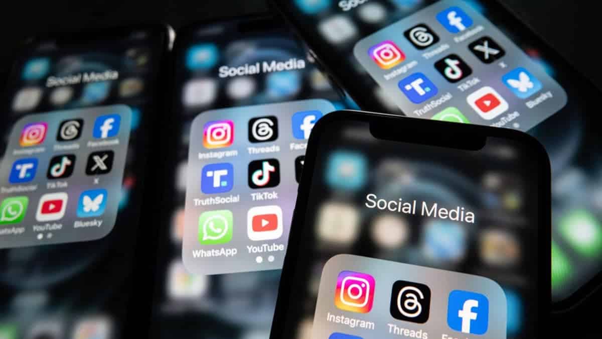 iPhone screens display logos of Instagram, Threads, Facebook, Truth Social, TikTok, X, WhatsApp, YouTube, and Bluesky in a photo illustration.