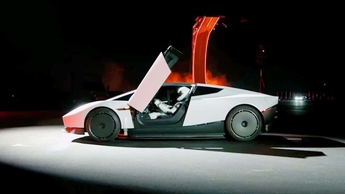 A driver sits in a Tesla Roadster.